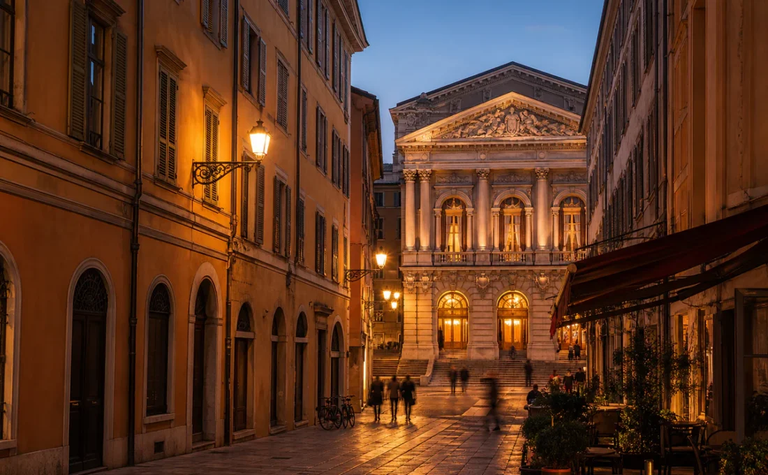 Vue éditoriale d'une rue ancienne du Vieux-Nice menant vers un bâtiment de théâtre historique en lumière dorée.